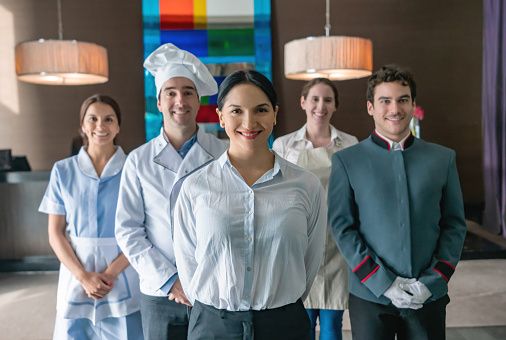 Professional hospitality and household staff team standing together in a luxury setting.