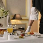 Professional household staff preparing and serving breakfast in a luxury home.