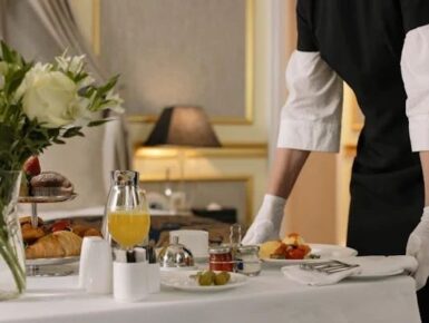 Professional household staff preparing and serving breakfast in a luxury home.