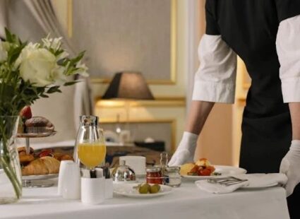 Professional household staff preparing and serving breakfast in a luxury home.